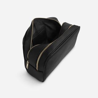 Personalised black leather toiletry bag showing interior storage and gold zips